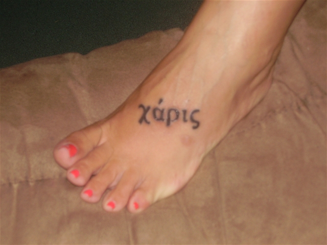 On her left foot is the greek word karis a word that is translated in our